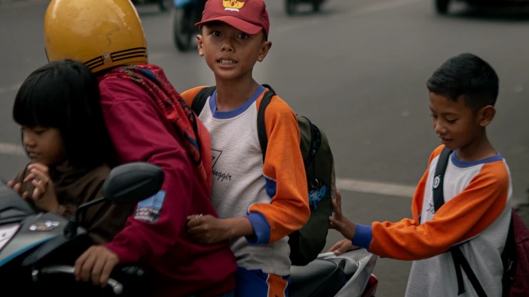 밝게 웃으며 학교로 향하는 아이들과 함께 걷는 도우미