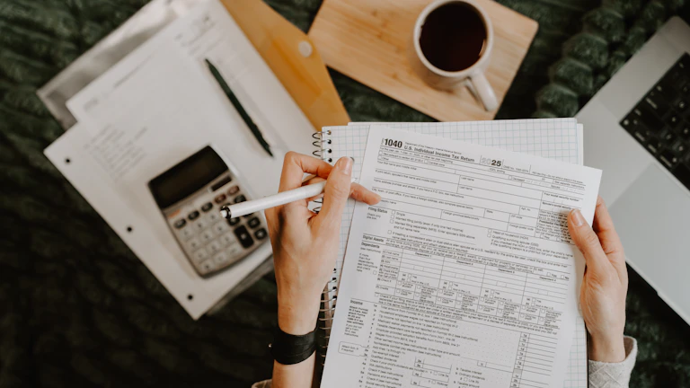서류와 계산기가 놓인 책상 위 모습