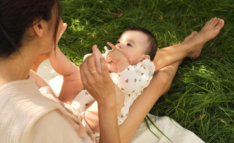 공원에서 아기와 함께 즐겁게 산책하며 웃고 있는 젊은 부부의 모습