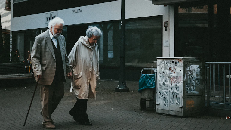 해변을 손잡고 걷는 노부부