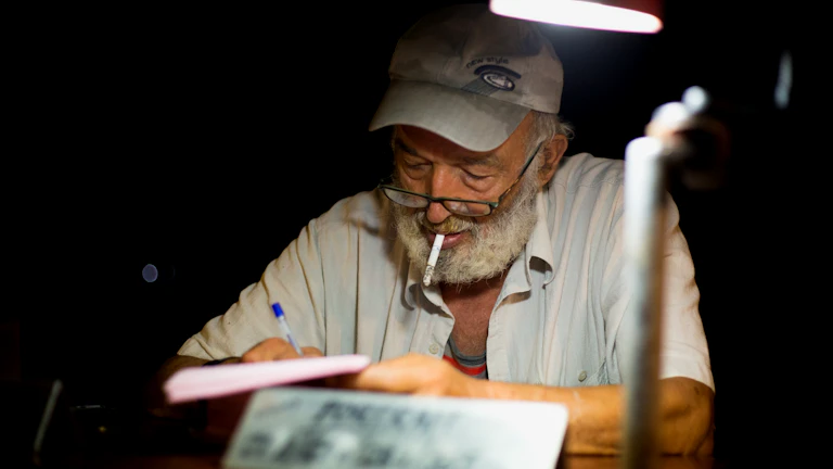 노인이 서류에 서명하고 있는 모습