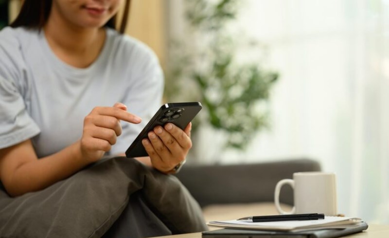 스마트폰으로 신용 점수를 확인하며 미소 짓는 사람