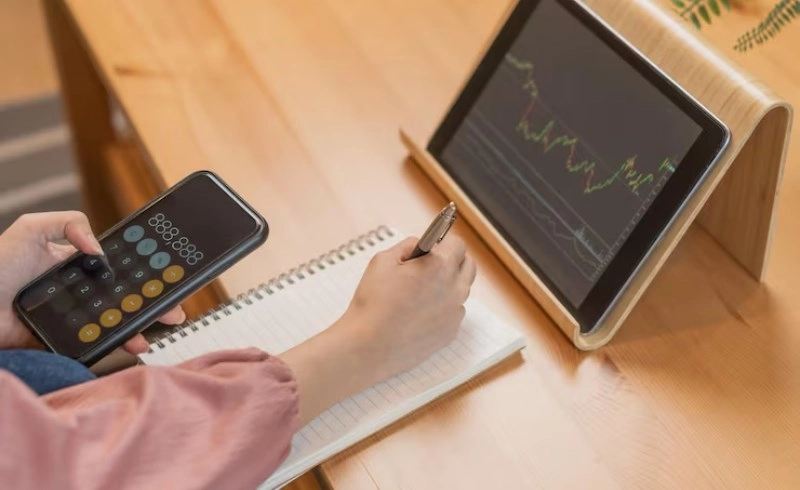 주식 물타기 계산기 활용법, 평단가 낮추고 탈출하는 필승 분할 매수 전략 4 주식 거래 차트와 계산기를 함께 보고 있는 모습