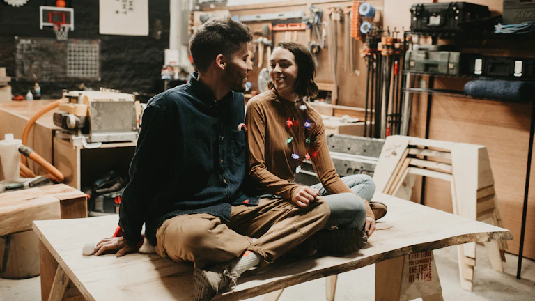 집 모형을 바라보는 젊은 부부